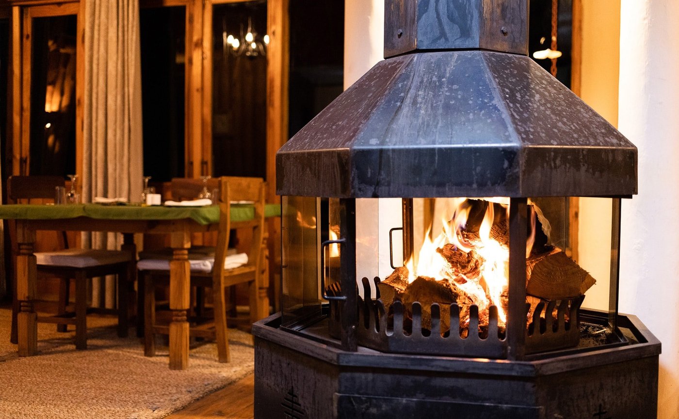 A freestanding fireplace warms the dining room at Chelinda Lodge