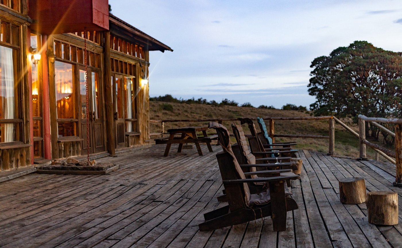 Adirondack chairs line the timber deck at dusk, Chelinda Lodge
